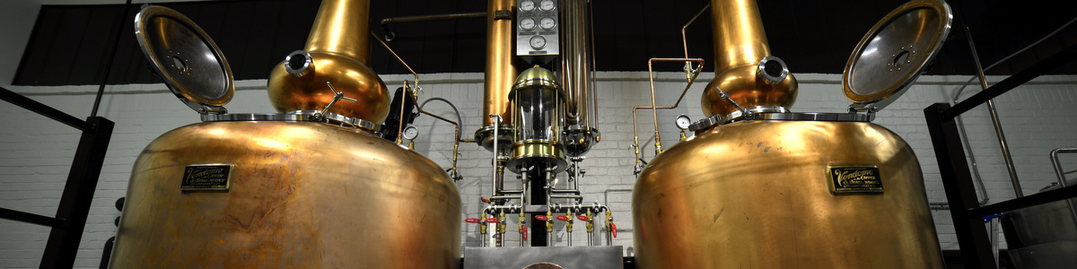 Two copper pot stills and central distilling equipment inside ASW Distillery.
